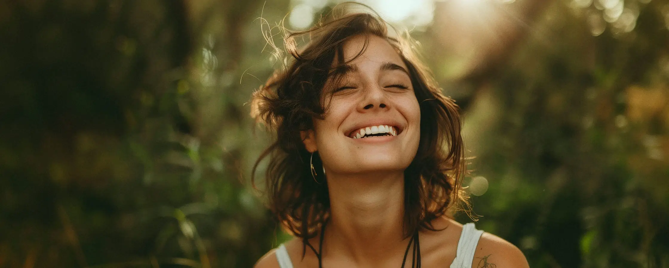 Young satisfied woman smiles into the sun
